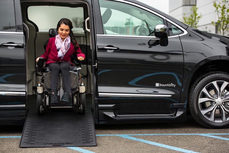Woman in wheelchair getting into vehicle