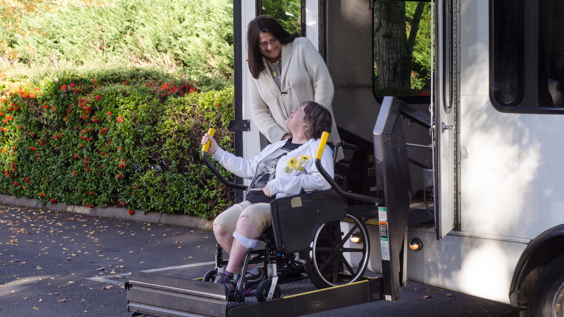 Wheelchair accessible commercial van with rear doors open, showing an installed accessible lift and securement system